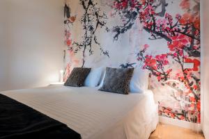 una camera con un letto con una parete floreale di Tra gli Alberi e il Mare a Sirolo
