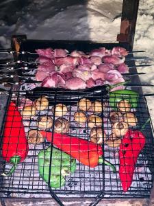 a grill with meat and fruit on top of it at AVIATOR Apartments in Bakuriani in Bakuriani