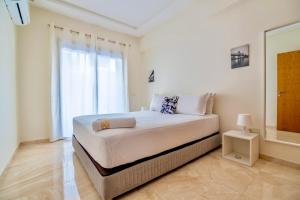 a white bedroom with a large bed and a window at Luxurious KING Bed SUITE W/POOL. Well centered. in Marrakech