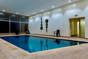 a large swimming pool in a building with at Luxurious KING Bed SUITE W/POOL. Well centered. in Marrakech