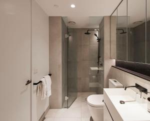 e bagno con servizi igienici, lavandino e doccia. di 'Modern Minimalism' Slate Chic in the City a Melbourne