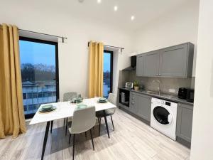 uma cozinha com uma mesa e uma sala de jantar em Beautiful High-Spec City Centre Flat - Next to Tube & Balcony em Londres