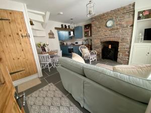 a living room with a couch and a fireplace at Cosy Fisherman’s Cottage: 150m to Brixham Harbour in Brixham