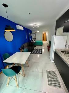 eine Küche mit einem weißen Tisch und einer blauen Wand in der Unterkunft Studio Acqua - estilo no melhor bairro da cidade in Niterói