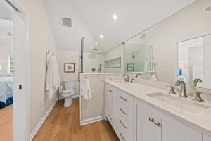 a white bathroom with two sinks and a toilet at 770 Spinnaker Beach House in Seabrook Island +26 photos
