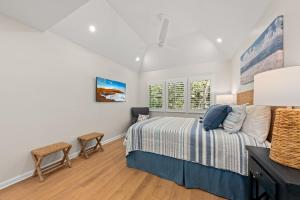 a bedroom with a bed and two chairs at 770 Spinnaker Beach House in Seabrook Island