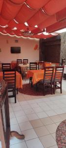 comedor con mesas y sillas y TV en Hotel Casa Kolping Quito, en Quito