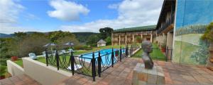 a building with a pool and a statue in front of it at Magoebaskloof Hotel in Tzaneen