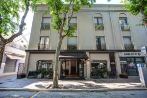 un bâtiment avec un arbre en face dans l'établissement Hotel Cristallo, à Cattolica