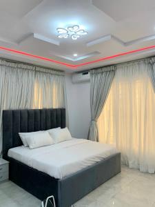 a bedroom with a large bed in front of a window at The Residenze Adeniyi Jone Ikeja in Lagos