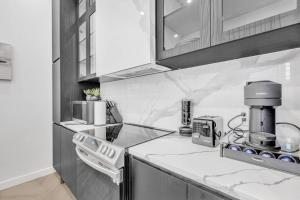 モントリオールにあるStylish 2-bedroom Getaway, Luxurious & Conveniently Located to Experience the Pulse of the City - Apt 5のカウンターにコーヒーメーカーが置かれたキッチン