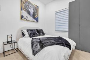 モントリオールにあるStylish 2-bedroom Getaway, Luxurious & Conveniently Located to Experience the Pulse of the City - Apt 5のベッドと壁に絵が飾られた寝室 +17枚の写真