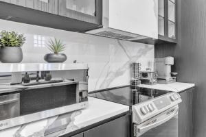 モントリオールにあるStylish 2-bedroom Getaway, Luxurious & Conveniently Located to Experience the Pulse of the City - Apt 5のコンロと電子レンジ付きのキッチン