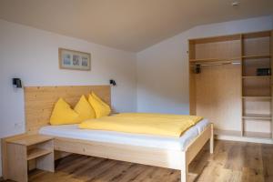 a bedroom with a bed with yellow pillows at Residence Montana in Resia