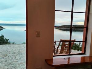 um quarto com uma janela com vista para um corpo de água em ECO CABAÑA INTIWAT'A em Comunidad Challapampa
