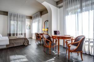 - une chambre avec une table, des chaises et un lit dans l'établissement Hotel Cristallo, à Cattolica