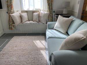 a living room with two blue couches and a window at Cosy Fisherman’s Cottage: 150m to Brixham Harbour in Brixham