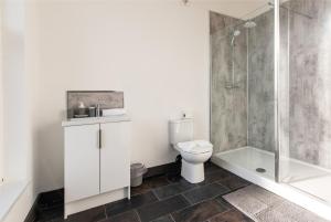 y baño con aseo y ducha. en Victoria Apartments: Contractor's Choice 3BR in Hartlepool, en Hartlepool