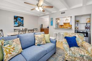 sala de estar con sofá azul y comedor en Steps to East Beach & Pet Friendly w/ 2 King Beds, en East End