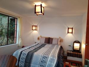 a bedroom with a bed and two lights on the wall at ECO CABAÑA INTIWAT'A in Comunidad Challapampa