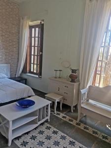 a bedroom with a bed and a table and two windows at Rincones con encanto in Cartagena