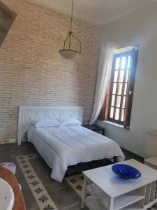 a bedroom with a white bed and a brick wall at Rincones con encanto in Cartagena
