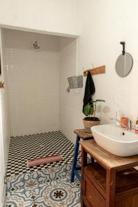 een badkamer met een witte wastafel en een bad bij Hartland Huis in Graaff-Reinet