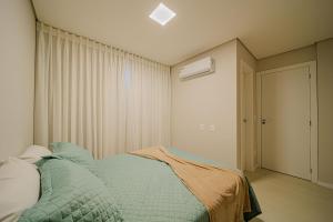 1 dormitorio con 1 cama con edredón azul en MORSE 1007 Charme e elegância para sua estadia, en Joinville