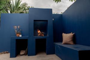 a blue wall with a fireplace and a bench at Hartland Huis in Graaff-Reinet