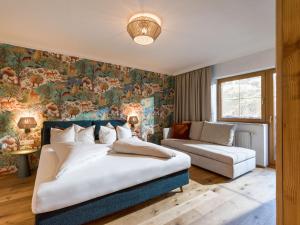 a bedroom with a bed and a couch at Alpin Family Resort Seetal in Kaltenbach