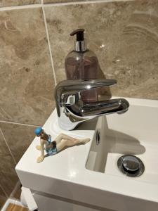 - un lavabo avec un robinet et une bouteille de savon dans l'établissement Most Easterly Guest House, à Pakefield