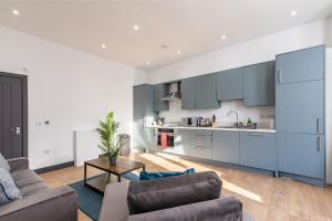 cocina y sala de estar con armarios azules en Victoria Apartments: Contractor's Choice 3BR in Hartlepool, en Hartlepool