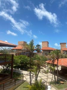 a view of a resort with palm trees and buildings at Pousada Tropical Ilhas in Aquiraz