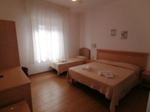 a hotel room with two beds and a window at HOTEL VILLA SANTANNA in Rimini