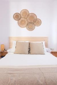 a bed with white sheets and pillows in a bedroom at Casita tentación con jacuzzi Privado in Málaga