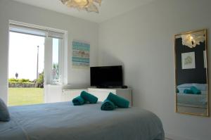 a bedroom with a bed with blue pillows on it at Tywyn Beach House in Tywyn