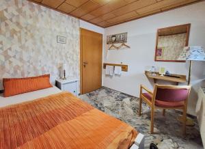 Pokój hotelowy z łóżkiem i biurkiem w obiekcie B & B Gästehaus Schmidt w mieście Lichtenberg