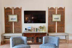 a living room with two chairs and a tv at Mandavilla - Inspired USVI in Cruz Bay