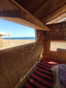 a room with a view of the beach and a rug at Makany Makanak Camp in Dahab