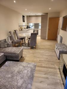 a living room with a table and chairs and a kitchen at Alderhouseplace in Maidenhead