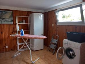 uma lavandaria com uma mesa e um frigorífico em Location Presqu'íle de Crozon-Morgat, au calme proche de la mer em Crozon