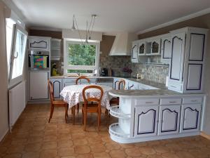 uma cozinha com armários brancos e uma mesa com cadeiras em Location Presqu'íle de Crozon-Morgat, au calme proche de la mer em Crozon