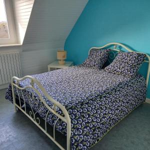 um quarto com uma cama com uma parede azul em Location Presqu'íle de Crozon-Morgat, au calme proche de la mer em Crozon