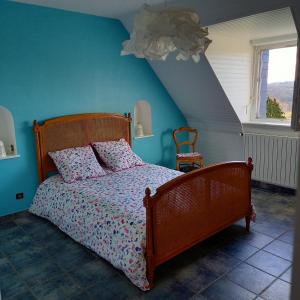 um quarto com uma cama e uma parede azul em Location Presqu'íle de Crozon-Morgat, au calme proche de la mer em Crozon