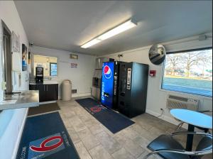a kitchen with a large refrigerator and a table in a room at Motel 6-Janesville, WI in Janesville