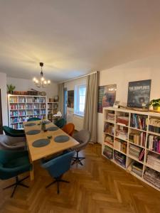 a dining room with a table and chairs and bookshelves at Miło mi in Karpacz