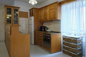 a kitchen with wooden cabinets and a refrigerator at Parga Center Apartment in Parga
