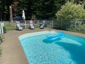 a swimming pool with a slide in the water at Luxury St-Sauveur Chalet with Swim Spa Close to Ski in Sainte-Adèle