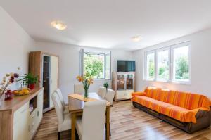 ein Wohnzimmer mit einem orangenen Sofa und einem Tisch in der Unterkunft Apartment Maurora Terrace in Zaton