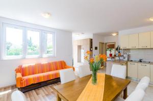 ein Wohnzimmer mit einem orangenen Sofa und einem Tisch in der Unterkunft Apartment Maurora Terrace in Zaton